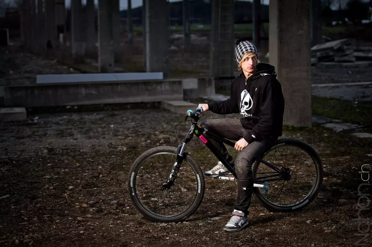 Jeune homme sur son vélo dans un décor industriel